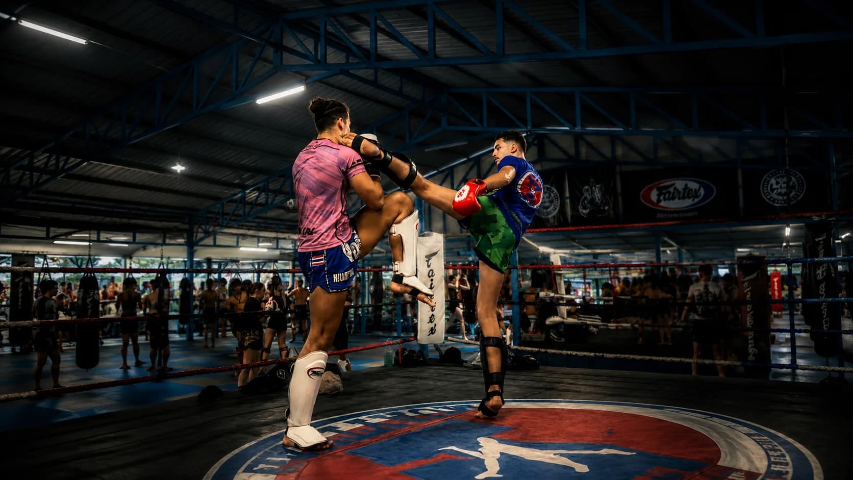 Deux combattants de Muay Thai à l'entraînement sur le ring de Yodyut Muay Thai à Koh Samui, l'un décochant un coup de genou